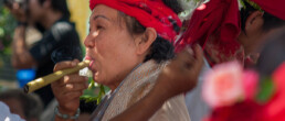 Old woman smoking at a ceremony near Lampang