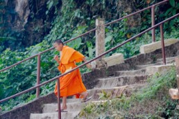Young monk running from stairs